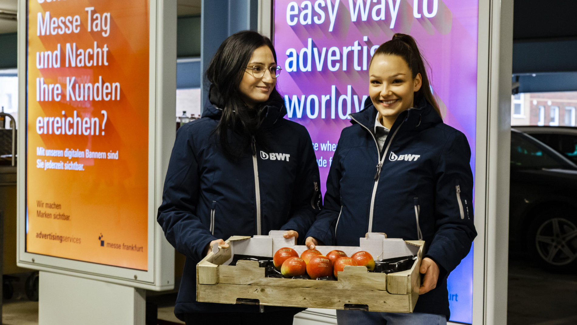 Promotion: 2 Hostessen mit einem Korb voller Äpfel