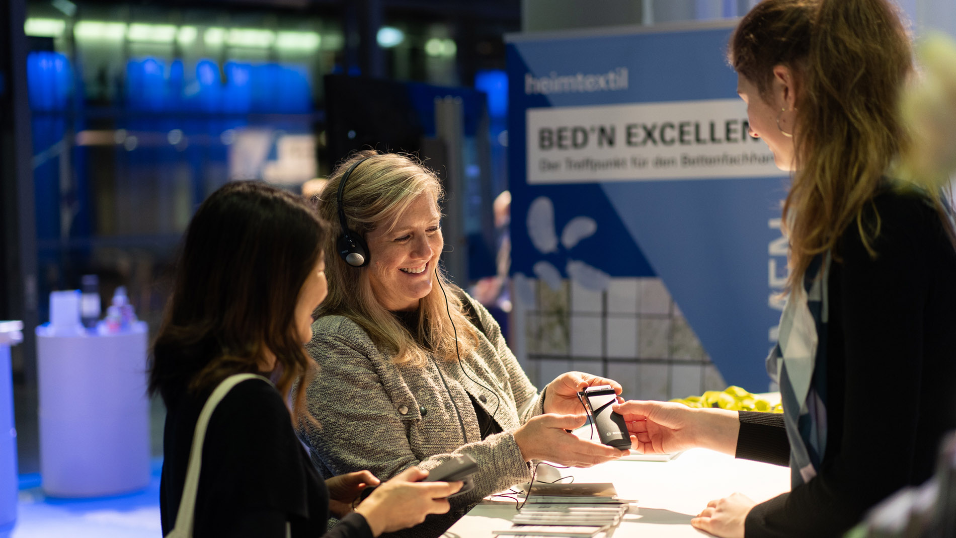 Heimtextil Bed'n Excellence Lounge: zwei Besucherinnen vor dem Counter