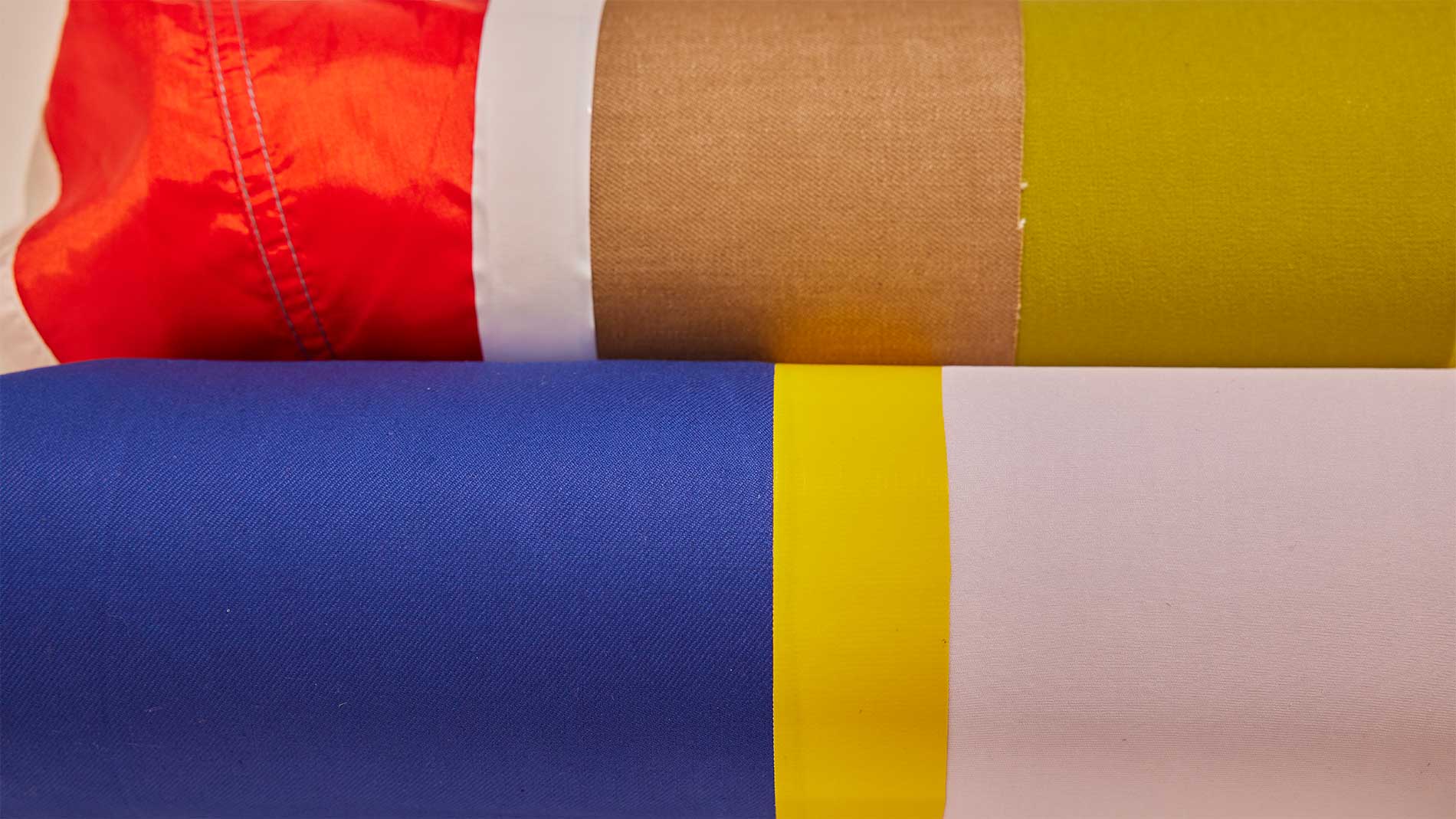 Restjes textiel op metalen cilinders die een veelkleurig patroon creëren.  Foto SPOTT voor Heimtextil