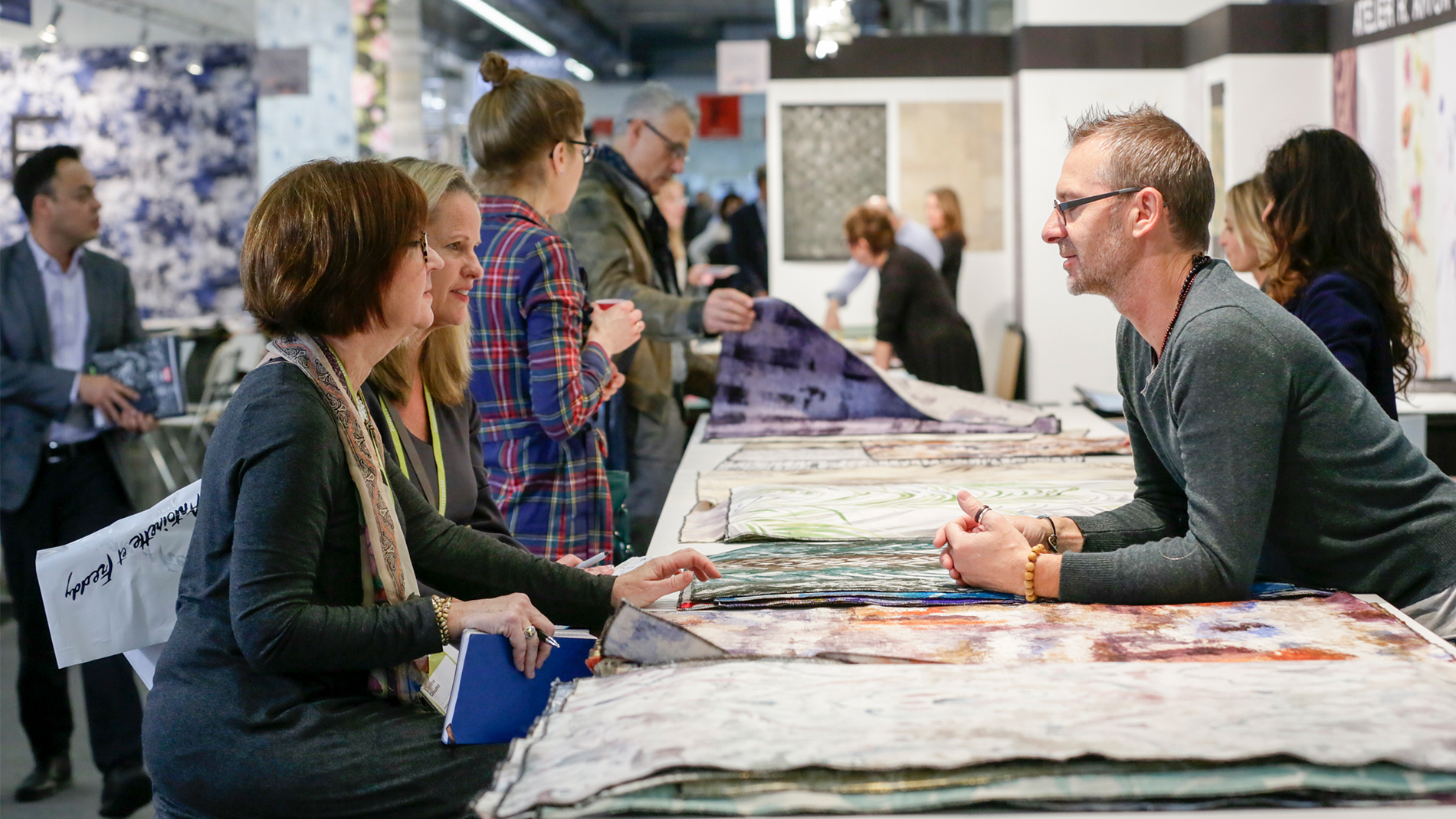 Visitors and an exhibitor are talking to each other at the last Heimtextil