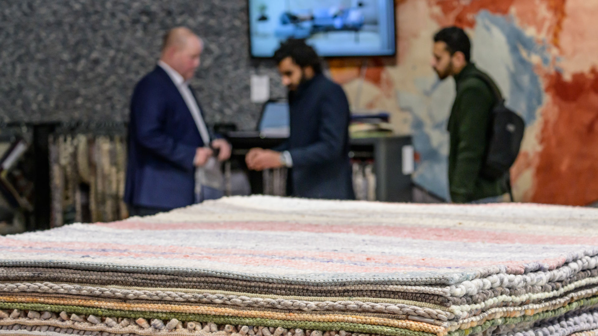 People in front of a pile of carpet samples