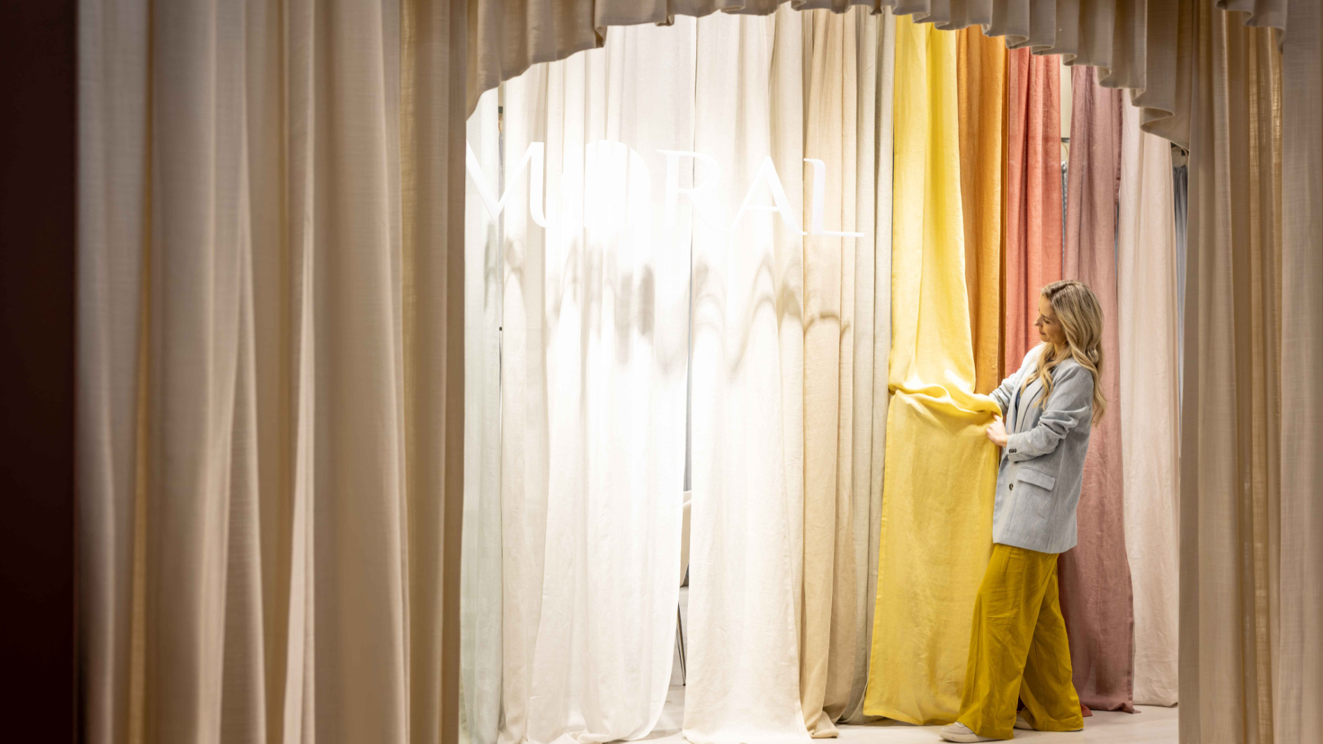 A woman is looking at curtains